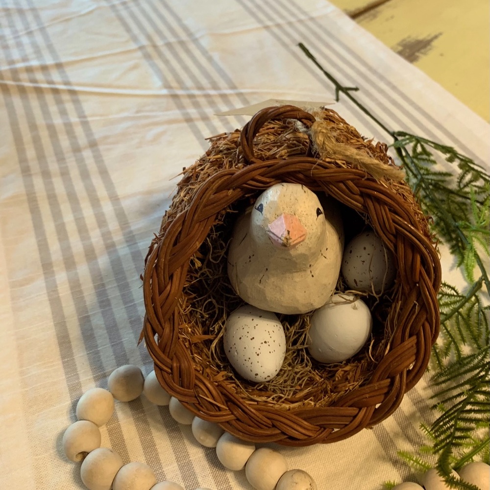 Ceramic bird with eggs in wicker basket
